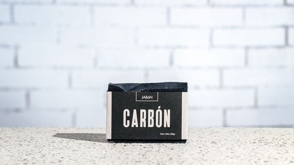 Charcoal bar soap on a textured surface