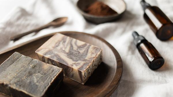 Natural bar soap and grooming items on a wooden board