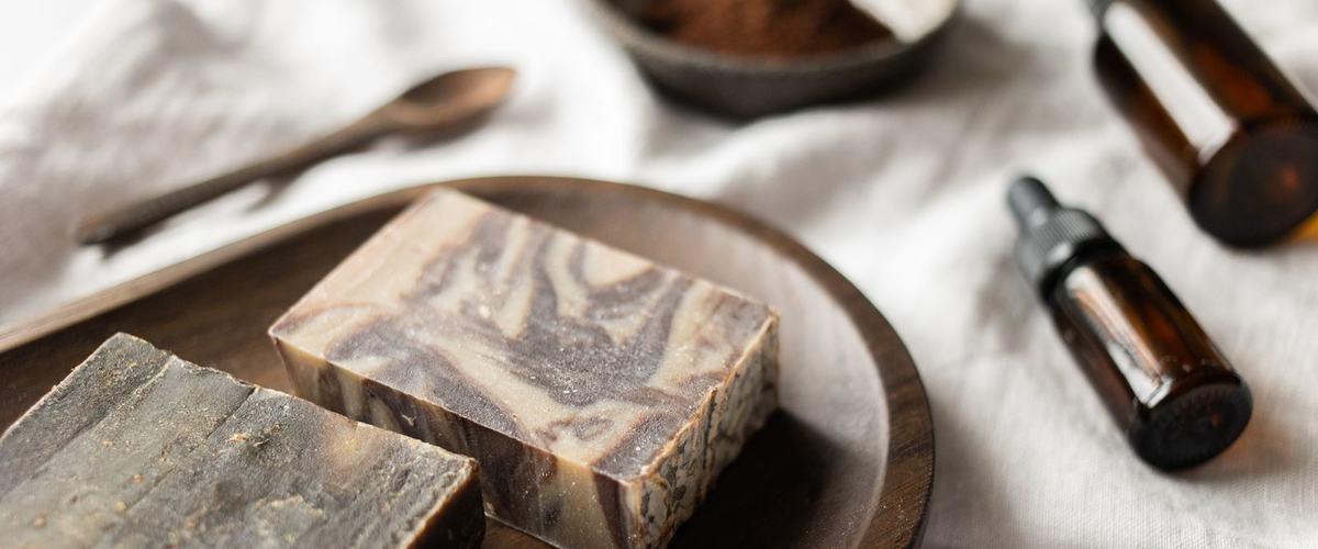 Handmade soap bars and grooming products arranged on a wooden board