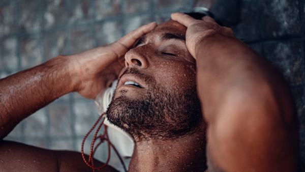 Man in a shower, bar soap versus body wash
