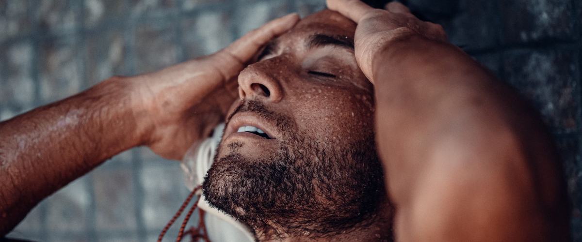 Man in a shower, bar soap versus body wash